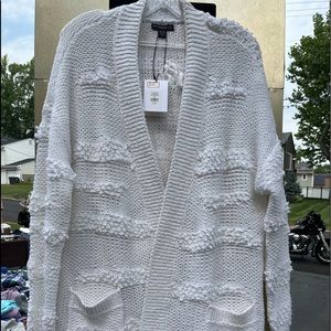 This is a knitted cardigan sweater by enTHREADS. brand new with tags